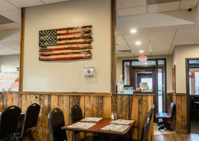 Interior shot of the dining space at Jill's Cafe with entry-way and an American flag in view